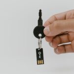 Dłoń trzymająca klucz z pendrive’em symbolizującym bezpieczeństwo danych