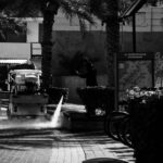 Pracownik sprzątający promenadę przy meczecie Al Rahim w Dubaju, zdjęcie b&w