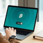Pracownik w biurze korzysta z laptopa z włączoną aplikacją VPN