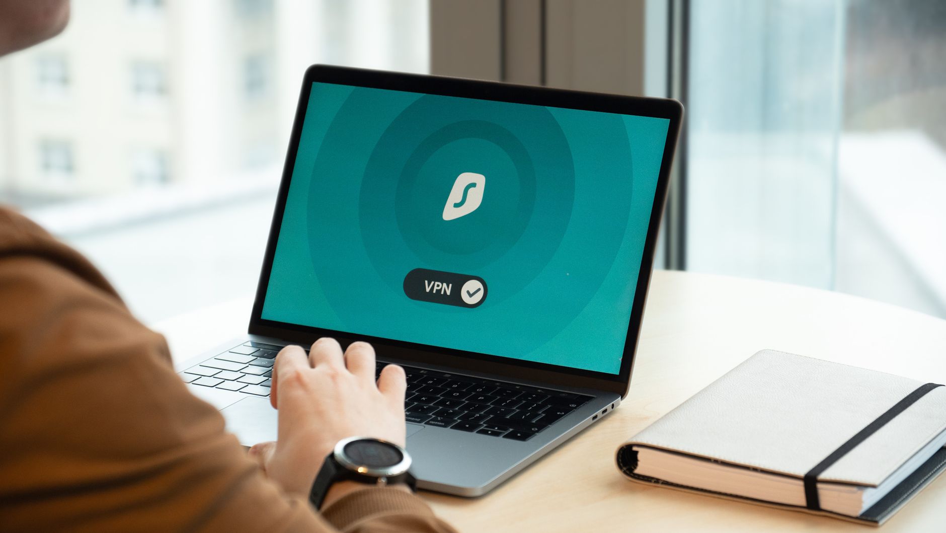 Pracownik w biurze korzysta z laptopa z włączoną aplikacją VPN