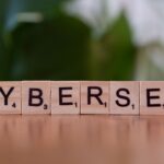 Drewniane kostki z napisem CYBERSEC na zielonym rozmytym tle