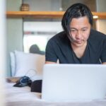 Mężczyzna pracuje na laptopie w przytulnym domowym wnętrzu