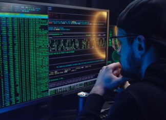 Jak przygotować pracowników na cyberataki szkolenia które naprawdę działają Pracownik analizuje kod na dwóch monitorach w ciemnym biurze