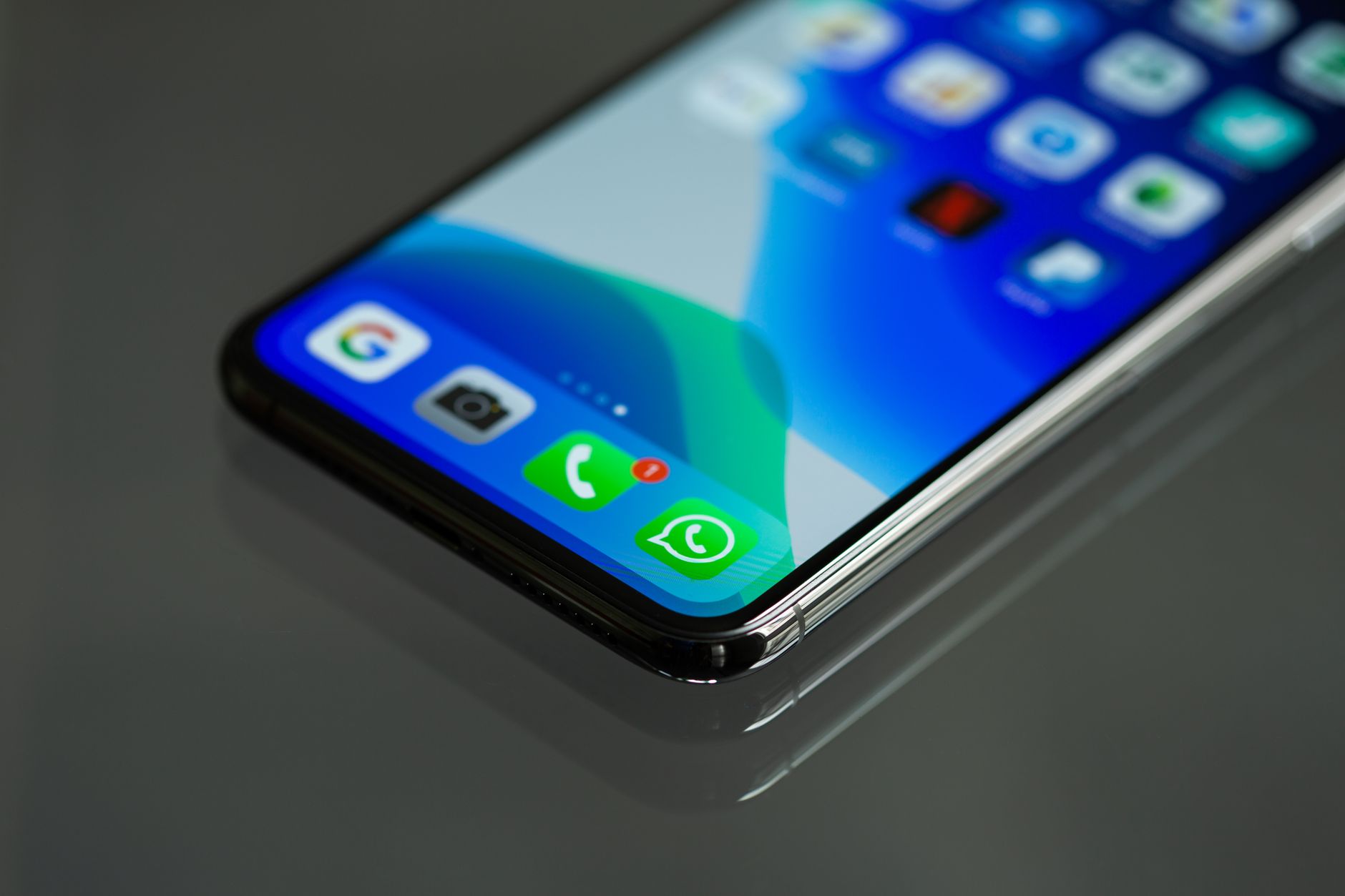Ekran smartfona z ikonami komunikatorów, w centrum ikona WhatsApp
