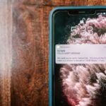 Smartfon na drewnianym stole z powiadomieniem o próbie oszustwa