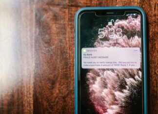 Messenger, WhatsApp, Signal: który komunikator jest naprawdę najbezpieczniejszy dla Twoich rozmów Smartfon na drewnianym stole z powiadomieniem o próbie oszustwa