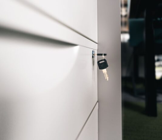 VeraCrypt vs BitLocker – który program lepiej zabezpieczy dysk laptopa przed kradzieżą? Klucz w zamkniętej szufladzie biurowej symbolizujący bezpieczeństwo danych